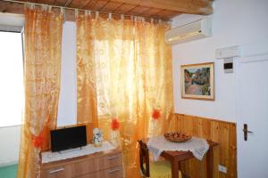 un salon avec une télévision et une table dans l'établissement Amalfi Coast Room, à Amalfi