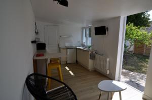 a small kitchen with a table and chairs in a room at Petite maison cosy-9mn à pied gare, 5 mn plage ! in Pornichet