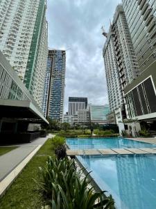 a swimming pool in a city with tall buildings at Cozy on the 28th! IT Park Cebu City in Cebu City