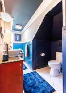 La salle de bains bleue est pourvue d'un lavabo et de toilettes. dans l'établissement Stylish Old Louisville 1 Bedroom Apartment, à Louisville