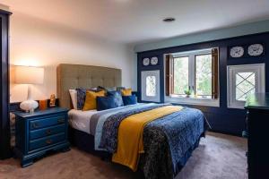 a blue bedroom with a bed and a window at Stylish Old Louisville 1 Bedroom Apartment in Louisville