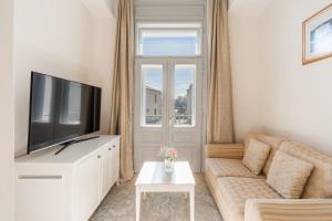 a living room with a couch and a flat screen tv at Hotel Bellevue - Liburnia in Opatija