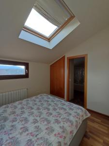 um quarto com uma cama e uma clarabóia em Casa adosada en Maçanet de Cabrenys em Maçanet de Cabrenys
