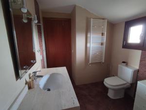 uma casa de banho com um lavatório branco e um WC. em Casa adosada en Maçanet de Cabrenys em Maçanet de Cabrenys