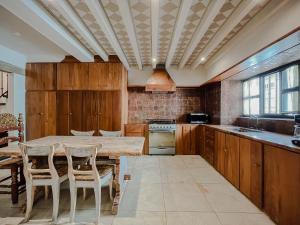 a kitchen with wooden cabinets and a table and chairs at Casa Chiquitos in San Miguel de Allende