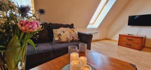 a living room with a couch and a table at Apartamenty przy Promenadzie mieszkania w ścisłym centrum in Mikołajki