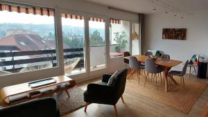 een woonkamer met een tafel en stoelen en een groot raam bij LE CLOS SAINT MICHEL 2 - 6 personnes, Centre, Parking in Annecy
