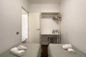 バルセロナにあるキー サグラダ ファミリア ＆ パーク グエル アパートメントのタオル付きのドミトリールームのベッド2台