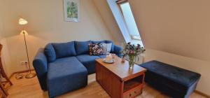 a living room with a blue couch and a table at Apartamenty przy Promenadzie in Mikołajki