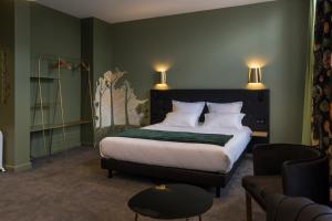 1 dormitorio con 1 cama, 1 silla y 1 sofá en Hôtel Loysel le Gaucher, en Montreuil-sur-Mer