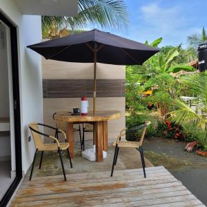 uma mesa e cadeiras com um guarda-sol num pátio em Casa Suite Palmar del viento FRENTE, FRENTE AL MAR em Moñitos