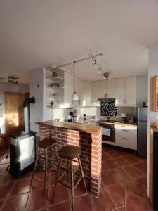 a kitchen with a brick counter and stools in it at Haus Karner in Neusiedl am See