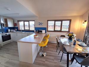 a kitchen and dining room with a table and chairs at River Breeze - Norfolk Broads in Brundall