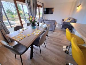 a dining room with a wooden table and chairs at River Breeze - Norfolk Broads in Brundall