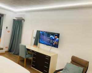 a room with a tv on a wall with a desk at Lavica Di Mezzo Apartments in Catania