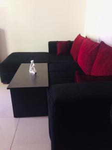 コスゴダにあるGrandfather Villaの黒いソファ(赤い枕付)、コーヒーテーブル