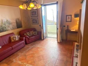 uma sala de estar com sofás vermelhos e uma porta de vidro deslizante em Nice Sicily Little family home em Acireale
