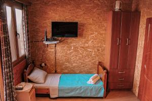 a small bedroom with a bed and a tv at River house Velero in Ulcinj
