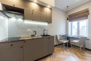 a kitchen with a sink and a table with chairs at Design Apartment on Mykhailivskyi Ln. 4 in Kyiv