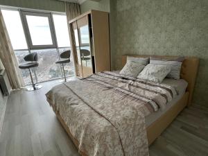 een slaapkamer met een bed en een groot raam bij Paris Evening in Chişinău
