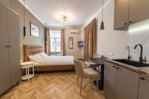 a room with a bed and a kitchen with a sink at Design Apartment on Mykhailivskyi Ln. 4 in Kyiv