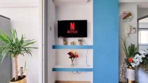 een kamer met blauwe planken met een tv en bloemen bij Modern Retreat: 2br Stylish Apt with Comfy Rooms! Smart TV with 200MBPS Internet in Larnaka