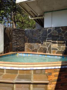 een klein zwembad met een stenen muur bij Casa Bondigua in Santa Marta