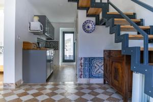 a kitchen with a staircase and a tile floor at Casota - Lusitália Eden in Sintra