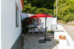 a patio with a table and an umbrella at Casota - Lusitália Eden in Sintra