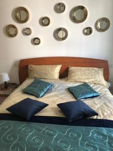 a bed with blue pillows and mirrors on the wall at Appartement GIUDECCA in Venice