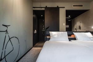 un paio di letti in una stanza con porta di Hotel Valkenburg by Mercure - Next to Shimano Experience Center a Valkenburg