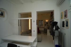 a room with a white table and a living room at Elegant And Modern Loft In Medieval Bologna in Bologna