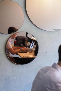 a reflection of a person at a desk in a mirror at Hotel Valkenburg by Mercure - Next to Shimano Experience Center in Valkenburg