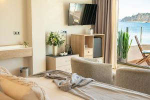 a bedroom with a bed and a tv and a window at La Sort Boutique Hotel in Moraira