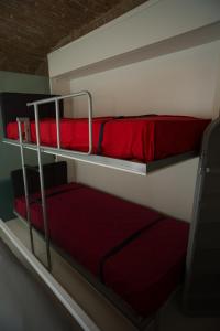 una camera con 2 letti a castello con lenzuola rosse di Elegant And Modern Loft In Medieval Bologna a Bologna