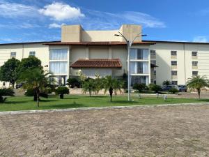a large building with palm trees in front of it at Class Hotel Passos Rio Grande Portal da Canastra in Passos