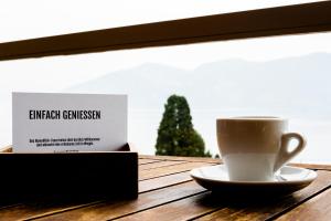 a cup of coffee sitting on a wooden table at Hotel Alpenblick in Weggis