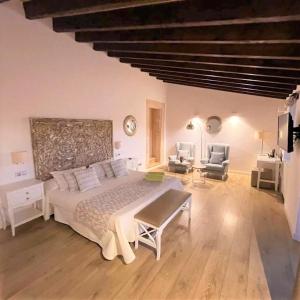 a bedroom with a large bed and a living room at Bennoc Petit Hotel - Only Adults in Llucmajor