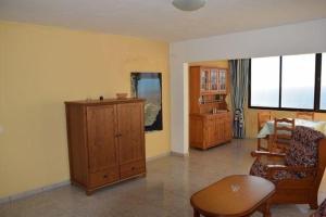 una sala de estar con un armario de madera y una mesa. en Appartement in Betancuria mit Garten und gemeinsamem Pool, en Valle de Santa Inés