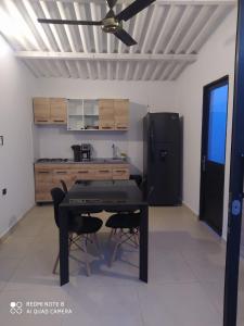 uma cozinha com uma mesa preta e um frigorífico preto em Casa Suite Palmar del viento FRENTE, FRENTE AL MAR em Moñitos