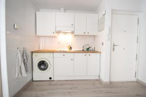 una cocina blanca con lavadora. en Apartamento los Pirineos Sabi, en Sabiñánigo