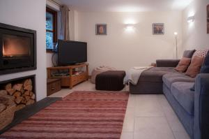 a living room with a couch and a tv at Llais Afon - 3 Bedroom Holiday Home - Fishguard in Fishguard