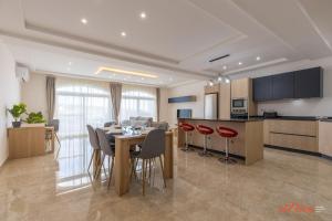 a kitchen and dining room with a table and chairs at The Grove Valley Views Apartment w/ Communal Pool in Xagħra
