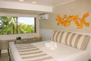 ein Schlafzimmer mit großem Bett und Fenster in der Unterkunft Cobertura com Piscina Privativa em Barra Bali, Pé na Areia, à Beira-Mar - Destino BSM 417 in Barra de São Miguel + 92 Fotos