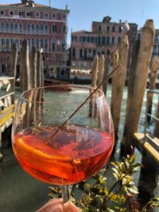 une personne détenant un verre de vin rouge dans l'établissement Appartement GIUDECCA, à Venise