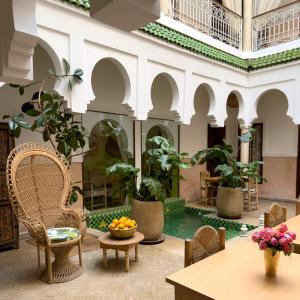 un vestíbulo con mesas de sillas y macetas en Monriad, en Marrakech