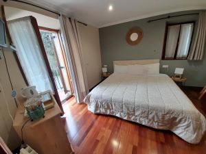 um quarto com uma cama grande e piso em madeira em Urrezko Ametsa em Sopuerta