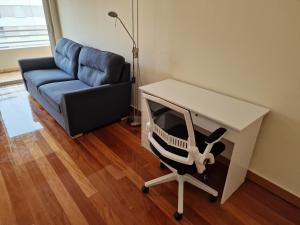 uma sala de estar com uma cadeira, uma secretária e um sofá em Green Park Ajuda Apartment no Funchal