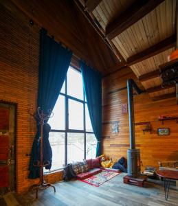 a room with a fireplace in a room with wooden walls at Sakudela in Nikortsminda