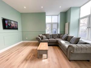 a living room with a couch and a table at Beautiful 2BR, Private Entry in Vibrant Leith in Edinburgh